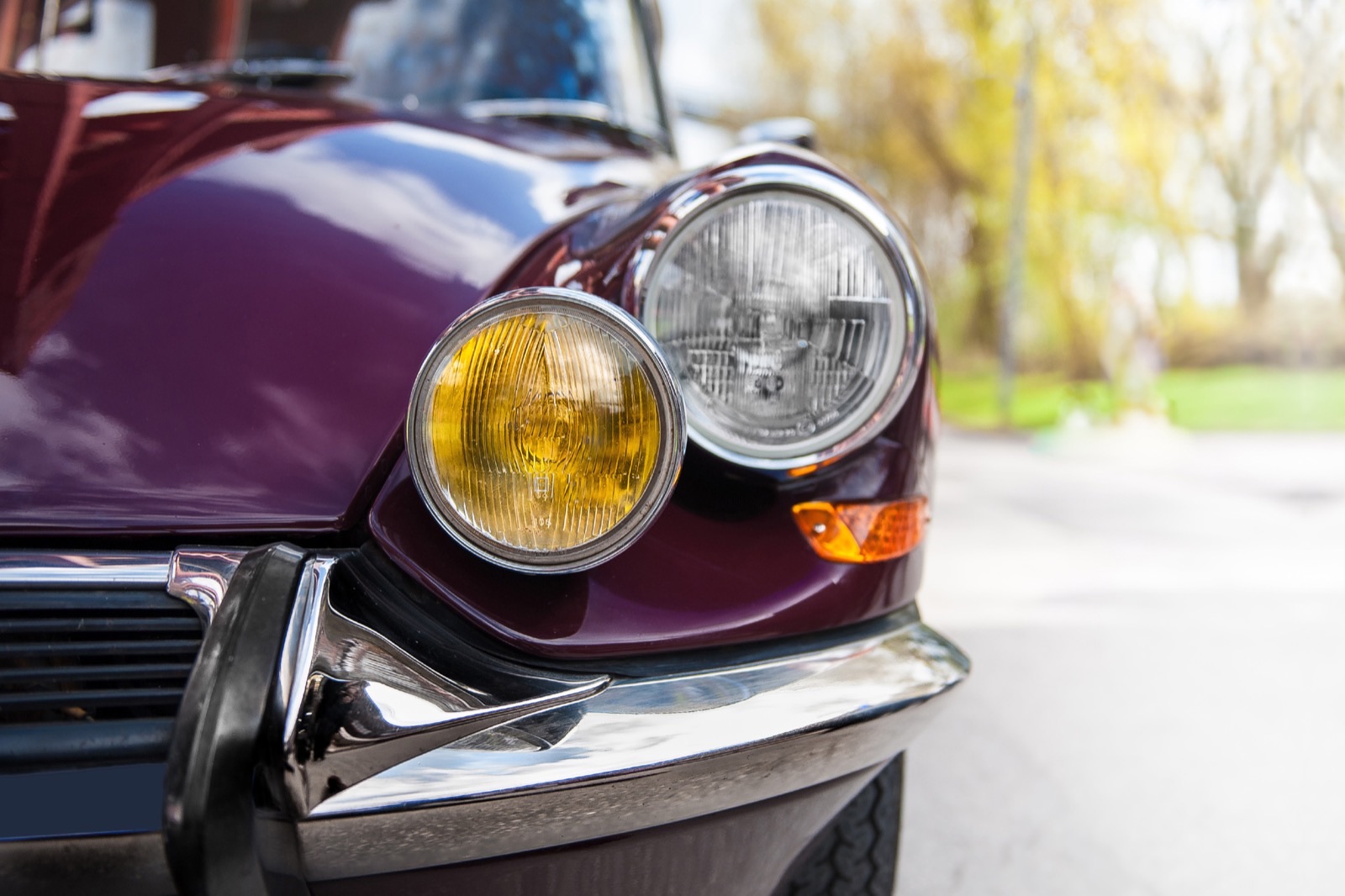 Scheinwerfer und Chrom eines weinroten Oldtimers