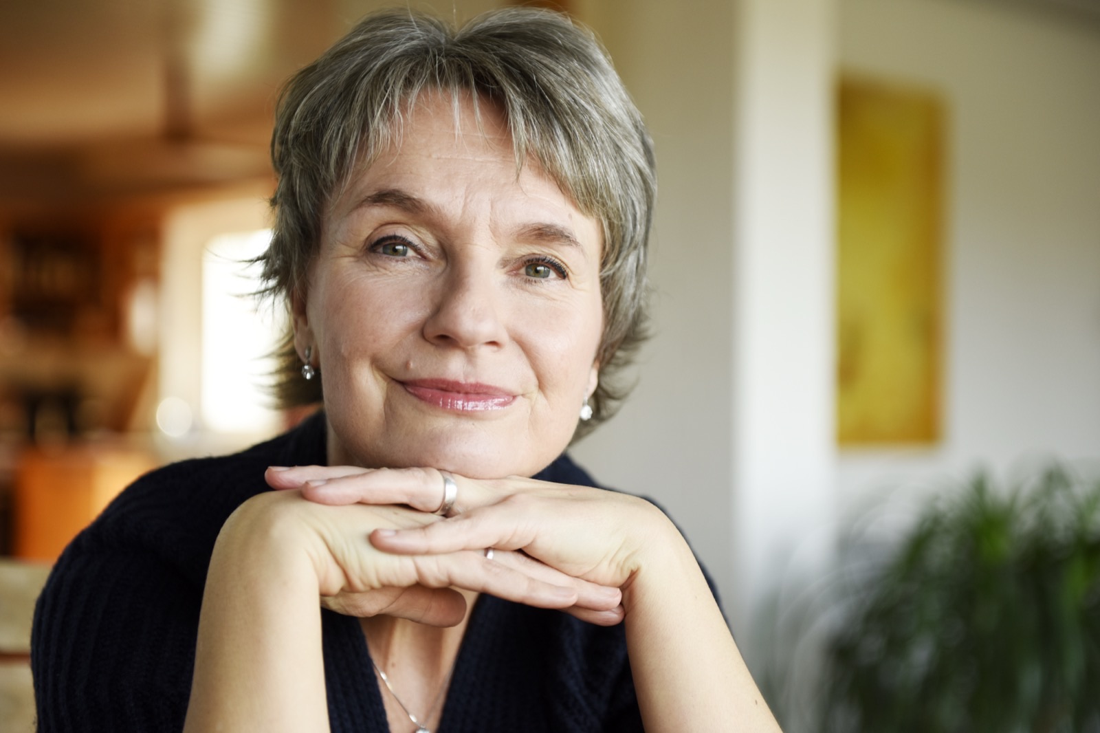 Jeanette Nentwig stützt das Kinn auf die verschränkten Hände und blickt nachdenklich in die Kamera